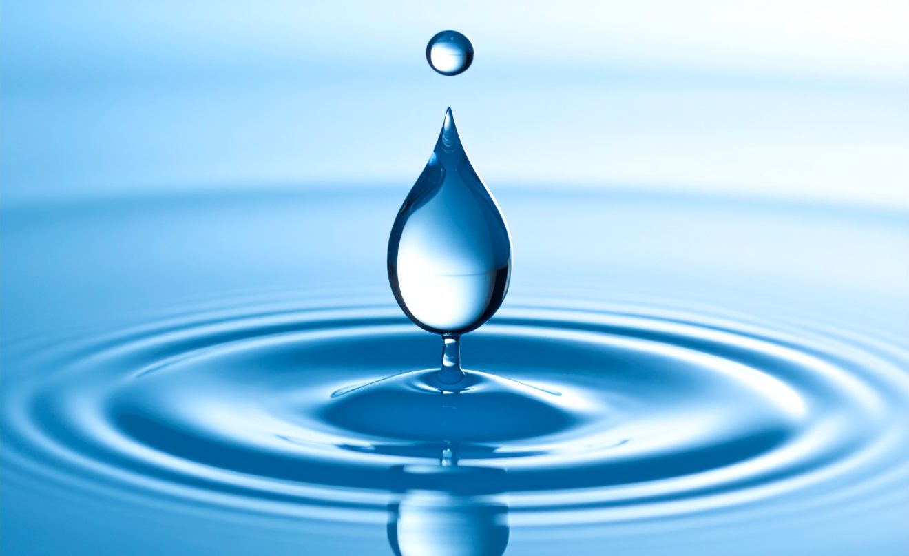 Impulse - ein Wassertropfen trifft auf eine glatte Wasseroberfläche